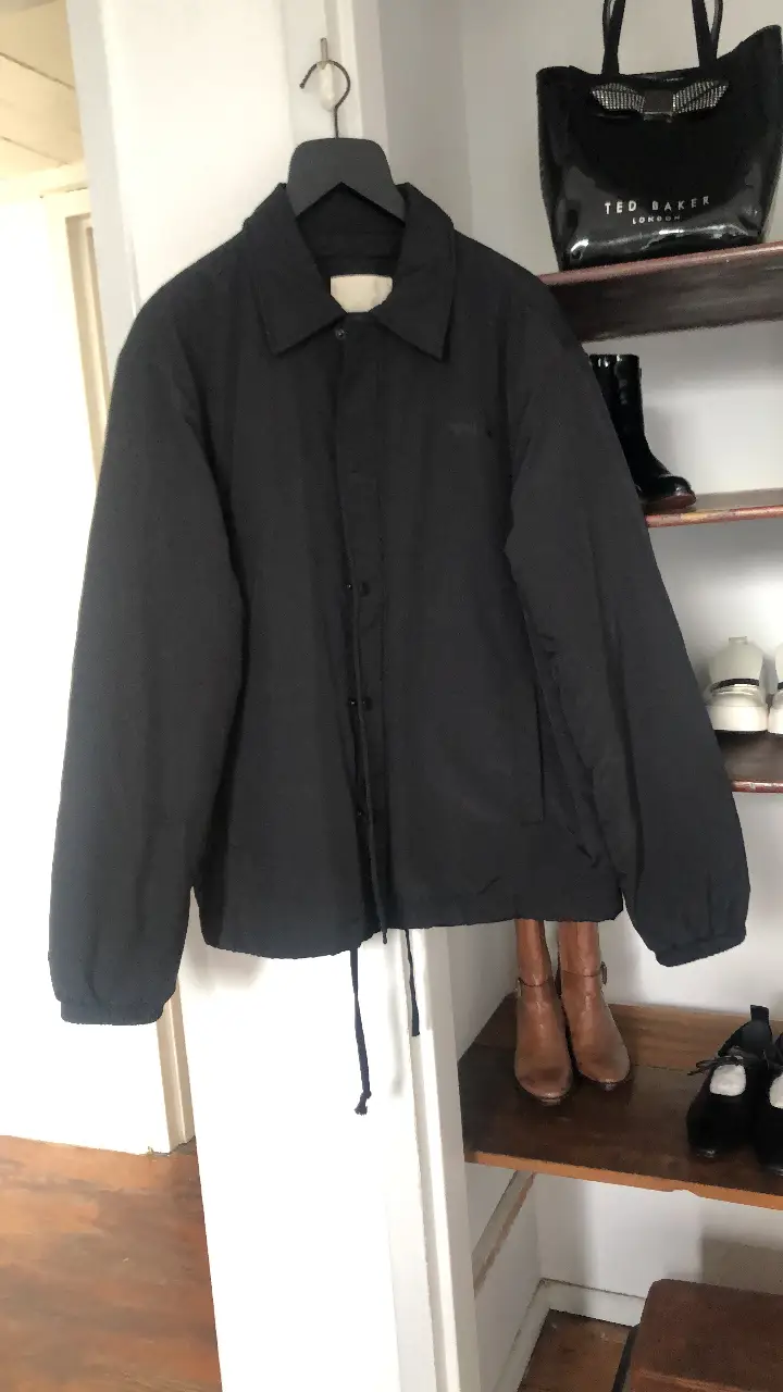 Campera bomber negra para hombre, con cuello camisero y cierre. Ideal para un look casual y moderno. Cuenta con un bolsillo interno y detalles de diseño.