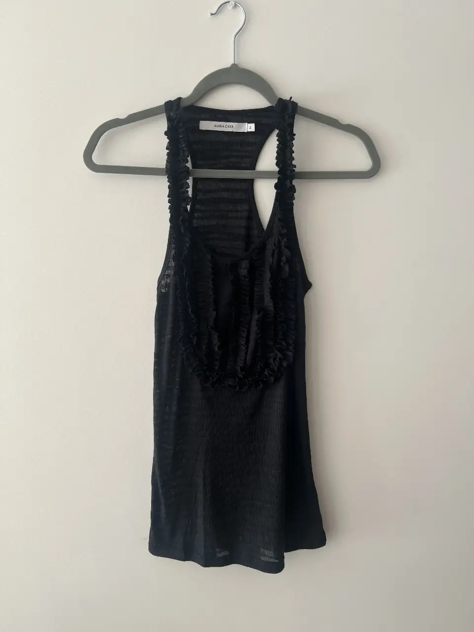 Musculosa negra con detalles de volados en el frente. Ideal para un look casual o para salir.