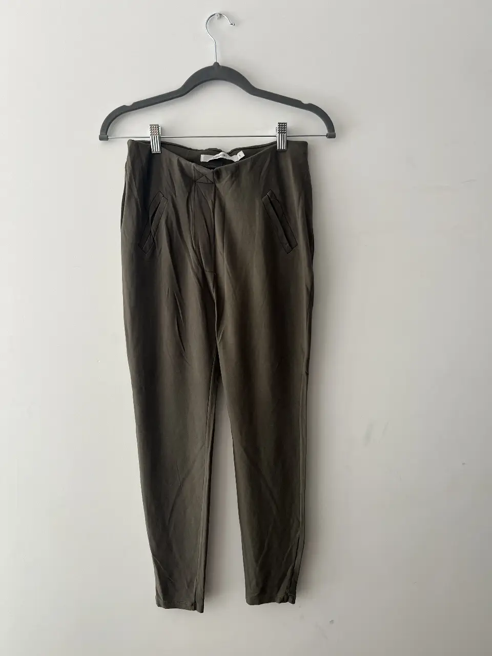 Calza de mujer, color verde seco. Tiro medio, con falsos bolsillos delanteros. Ideal para un look casual.