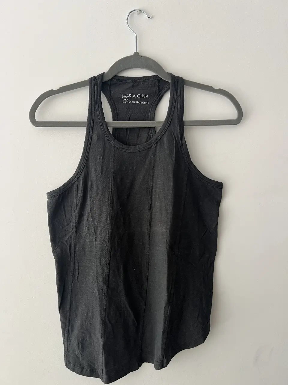 Musculosa gris oscura  de mujer, con espalda deportiva y detalle de costuras. Ideal para entrenar o para un look casual.