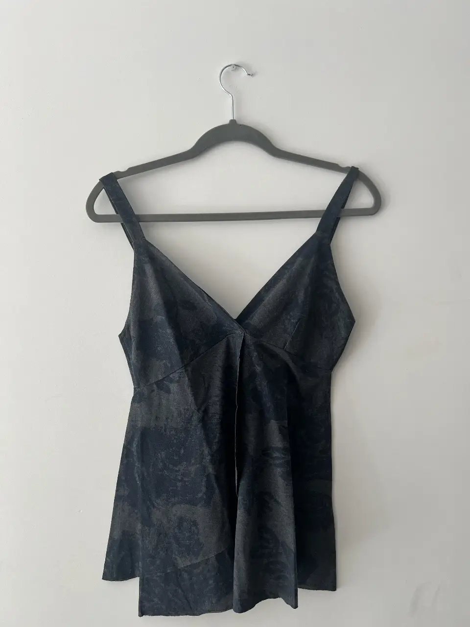 Top de mujer con estampado floral en tonos grises y azules. Diseño con escote en V y tirantes gruesos. Ideal para un look casual y moderno.