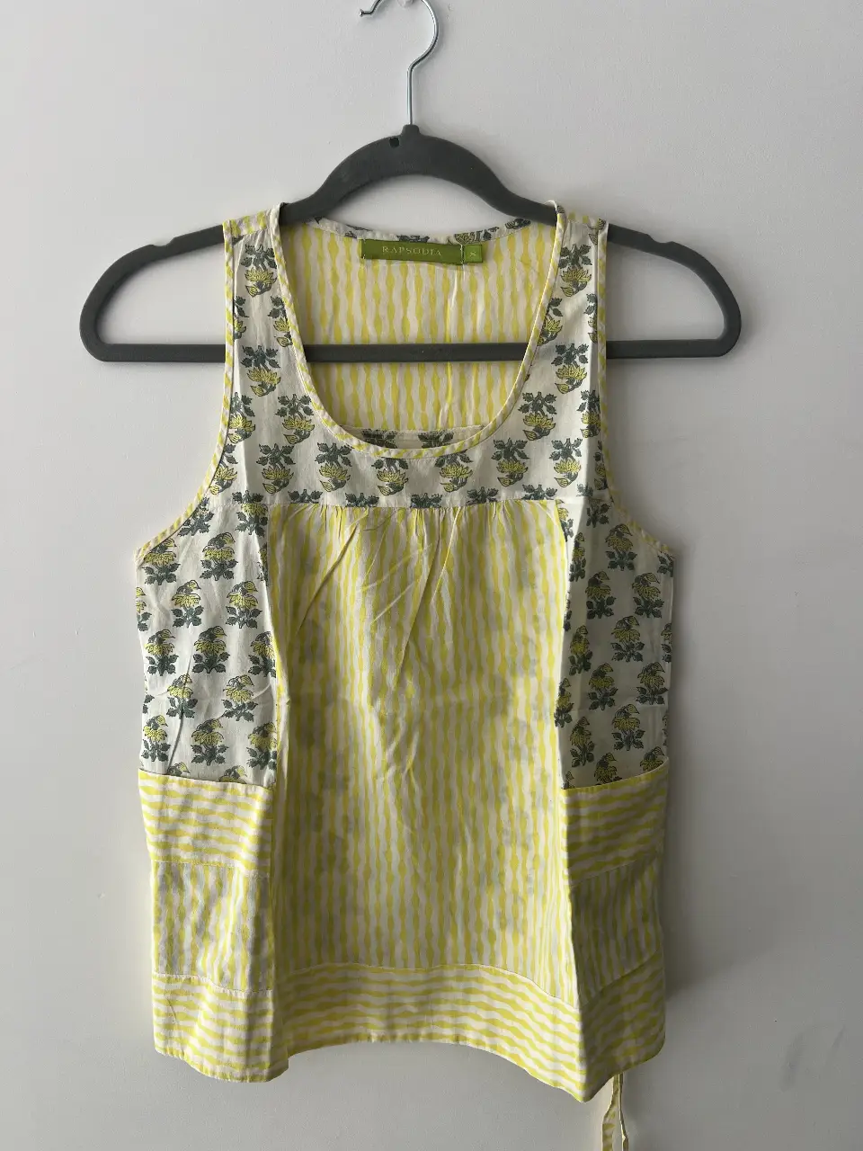 Musculosa de mujer con estampado floral en la parte superior y detalles a rayas amarillas y blancas. Ideal para un look fresco y casual.