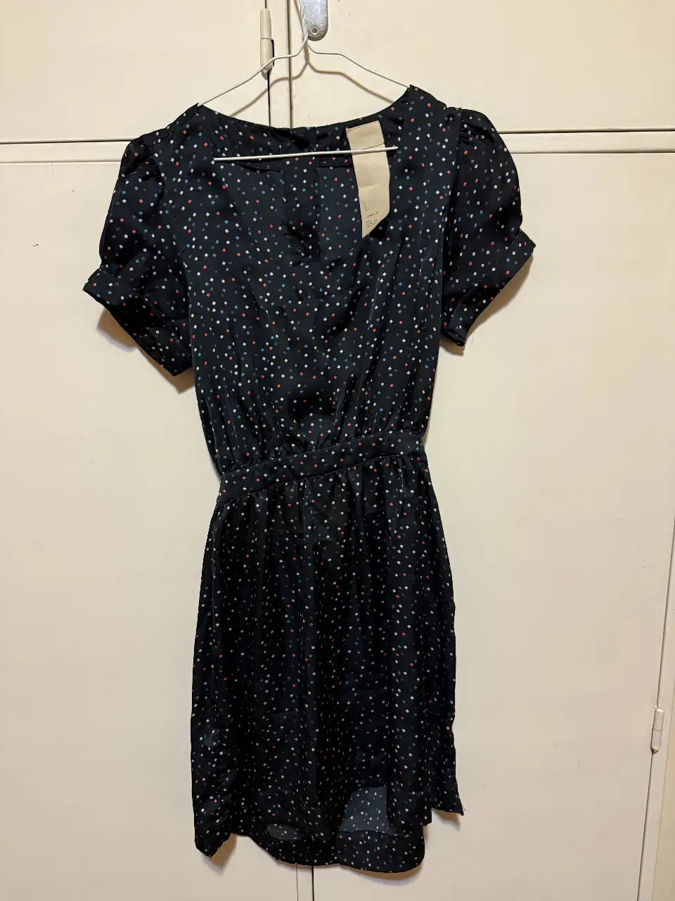 Vestido mini negro con estampado de lunares en varios colores. Tiene mangas cortas abullonadas y cintura entallada. Espalda con botones y cintura con elástico. Ideal para una salida o fiesta. Es L chico, funciona como M. Viene con botón extra. 