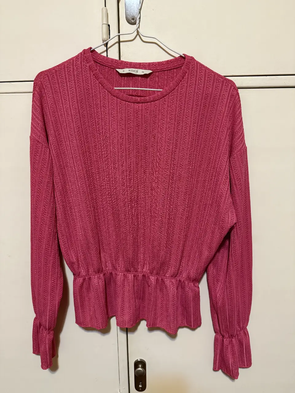 Blusa de manga larga color rosa con detalle de fruncido en la cintura y puños. Ideal para un look elegante y femenino. Sin usar.