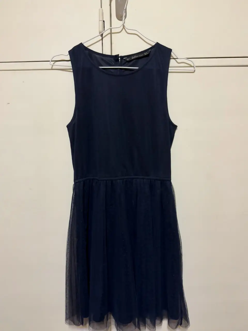 Vestido midi de fiesta, color azul marino. Confeccionado de tela y una capa de tul con bordado con puntitos. Botones en la espalda. Un solo uso.