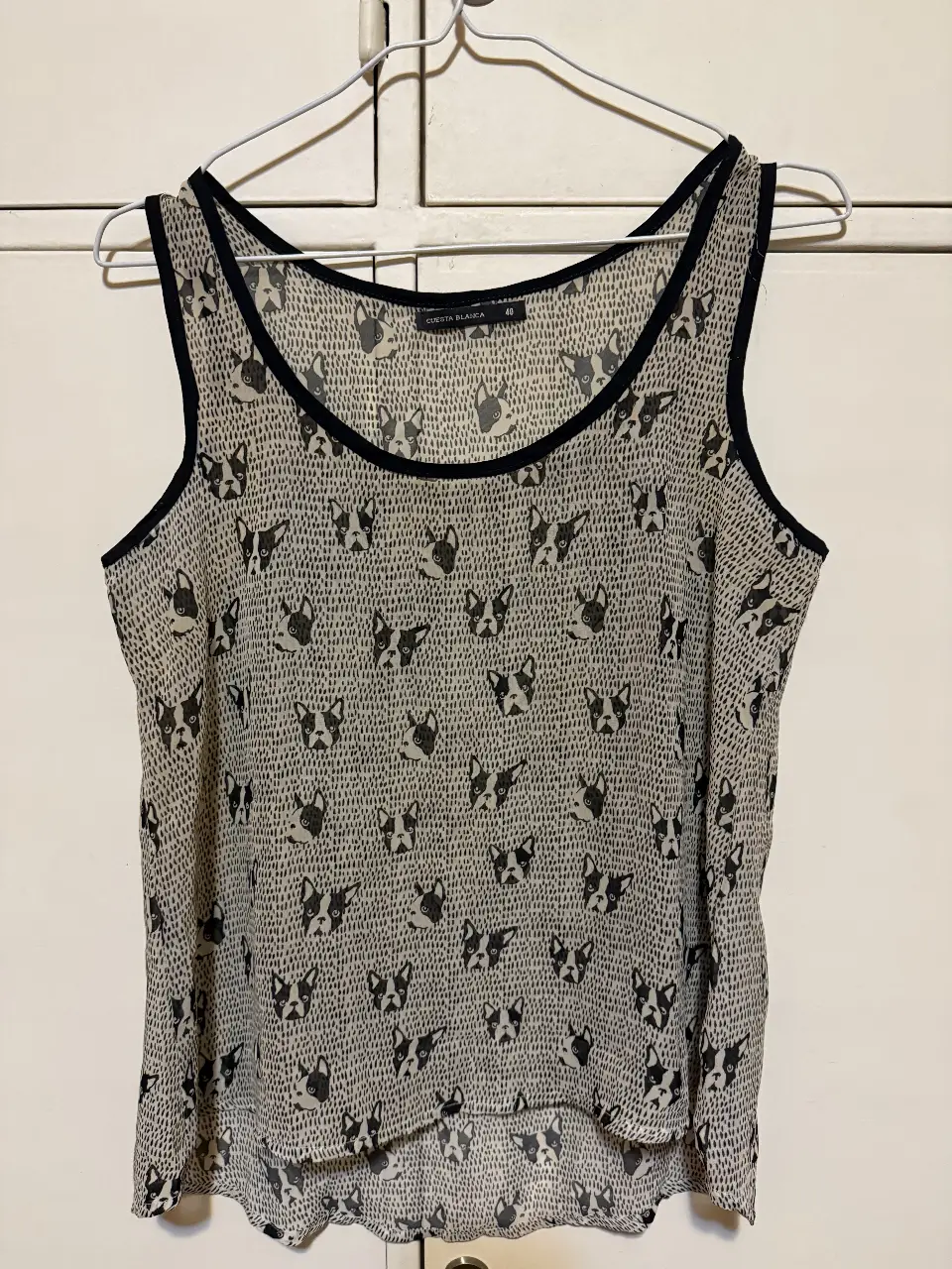 Blusa sin mangas con estampado de perros, ideal para un look casual y fresco. Confeccionada en tela ligera y cómoda, perfecta para el verano. Marca Cuesta Blanca.