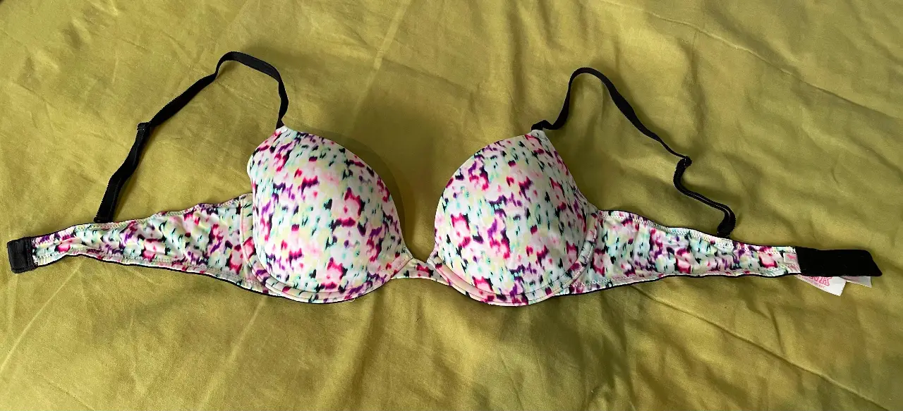 Corpiño Pink de Victoria's Secret, talle 34B, con estampado floral en tonos rosas y blancos. Breteles negros ajustables y detalles en negro. Ideal para uso diario.