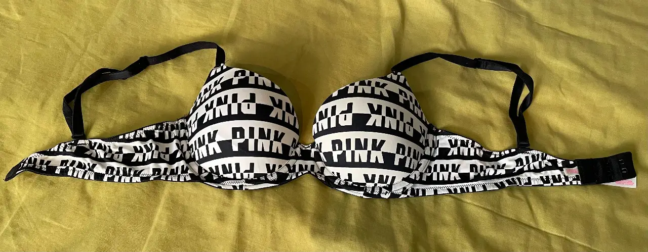 Corpiño Pink de Victoria's Secret, con estampado de letras en blanco y negro. Talle 34B, ideal para uso diario.