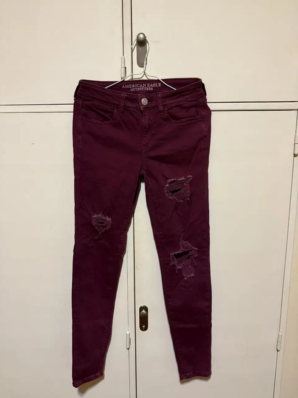 Jeans chupín de mujer American Eagle Outfitters, color borgoña con roturas en las rodillas. Talle 4 US, 36 arg tiro medio y calce ajustado. Ideal para un look casual y moderno. Color Bordó.