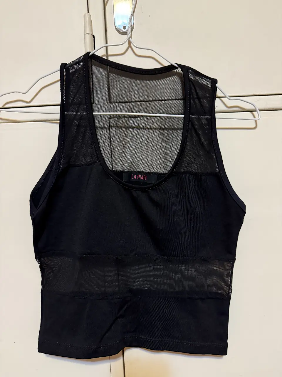Top negro con detalles de red, ideal para un look moderno y audaz. Perfecto para salir de noche.