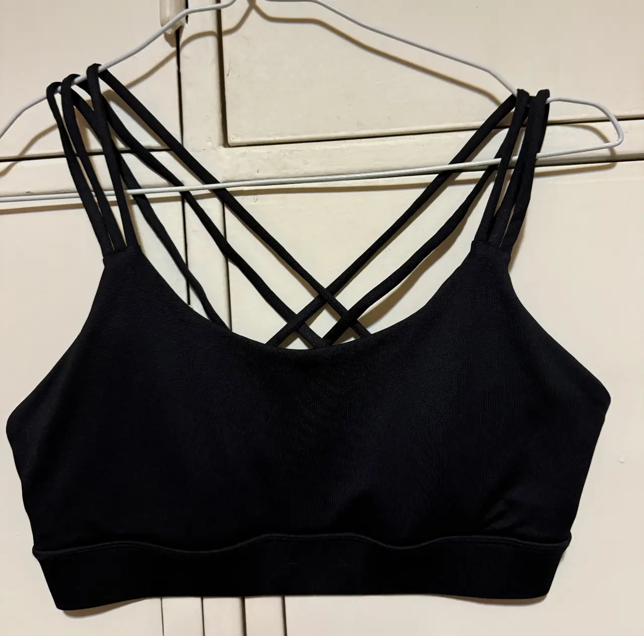 Top deportivo negro de Forever 21 con tiras cruzadas en la espalda. Ideal para entrenamientos de alto impacto. 