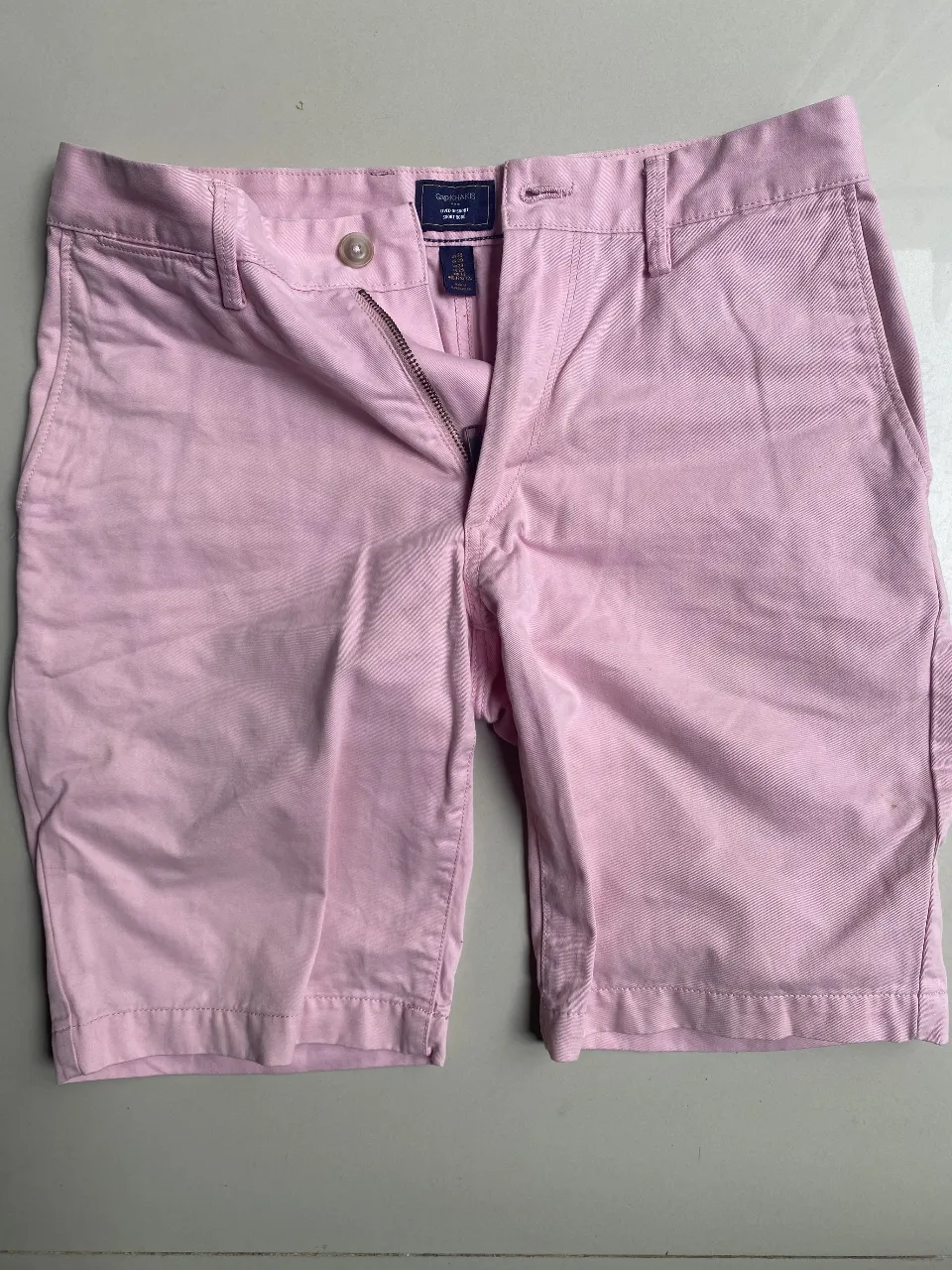 Bermudas color rosa pastel, tiro alto, con cierre y botón. Ideales para un look casual y fresco.