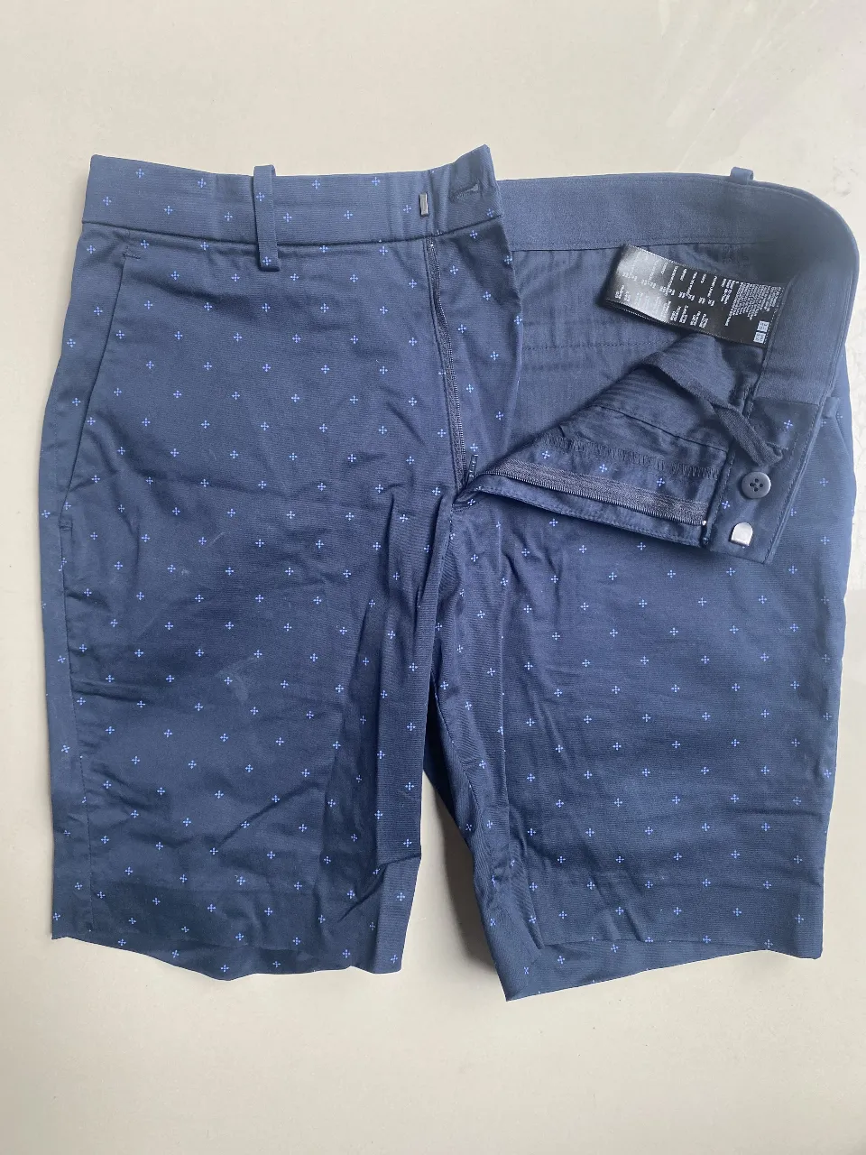 Bermudas de vestir azul marino con estampa de cruces pequeñas en azul Francia. Tiro alto, con cierre y botón. Ideales para un look casual o semi-formal.