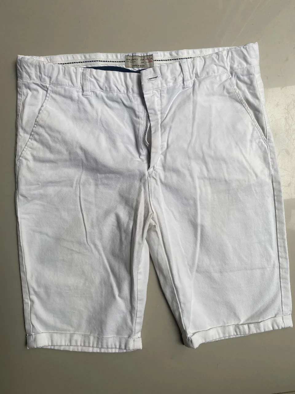 Bermudas de gabardina color hueso, tiro medio, con bolsillos al frente y atrás. Ideales para un look casual de día o para un look formal.