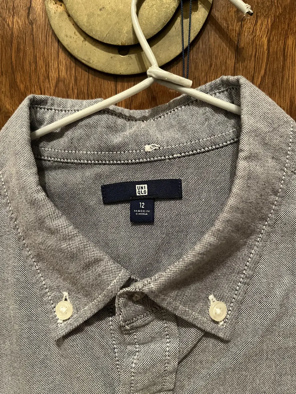 Camisa de niño de la marca Uniqlo, talle 12, color gris. Ideal para un look casual y versátil. Son 2 una gris la otra celeste claro