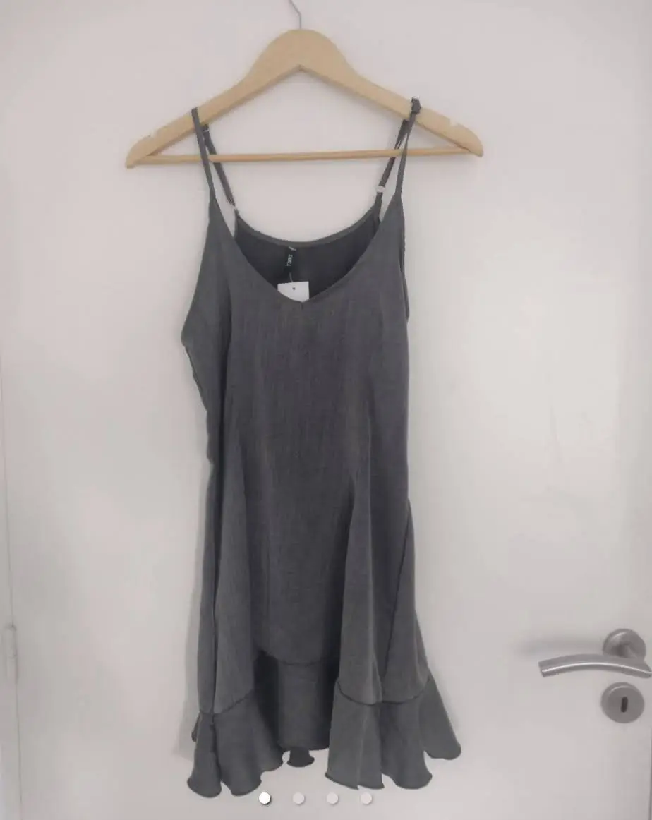 Vestido mini gris con tirantes finos y volados en el bajo. Ideal para un look casual y fresco. cuello en V. tiras regulables, cierre de costado. largo 85cms, cisa 40cms.