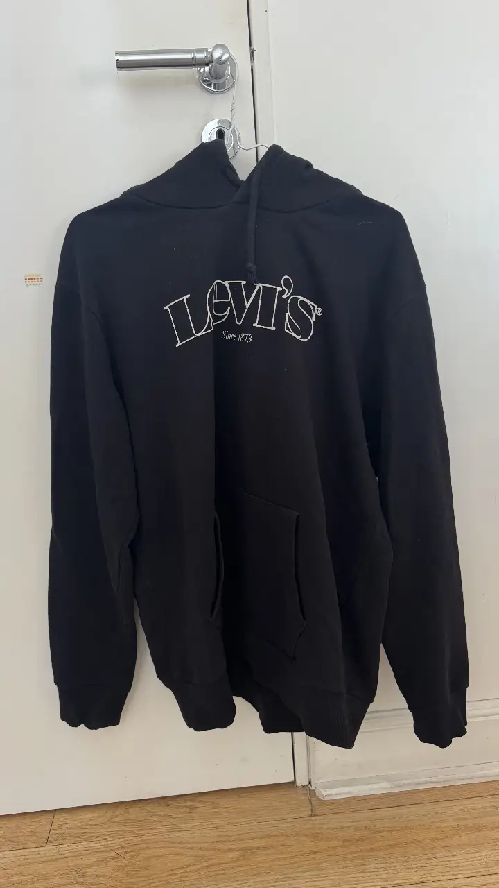 Buzo canguro negro de la marca Levi's, con el logo de la marca en blanco en el frente. Ideal para un look casual y cómodo.