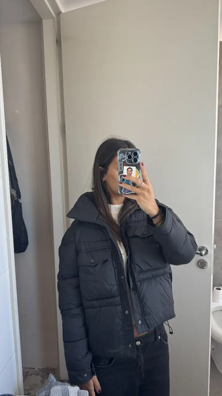 Campera puffer negra de mujer, con cuello alto y bolsillos. Ideal para el invierno. Marca Prüne, talle M.