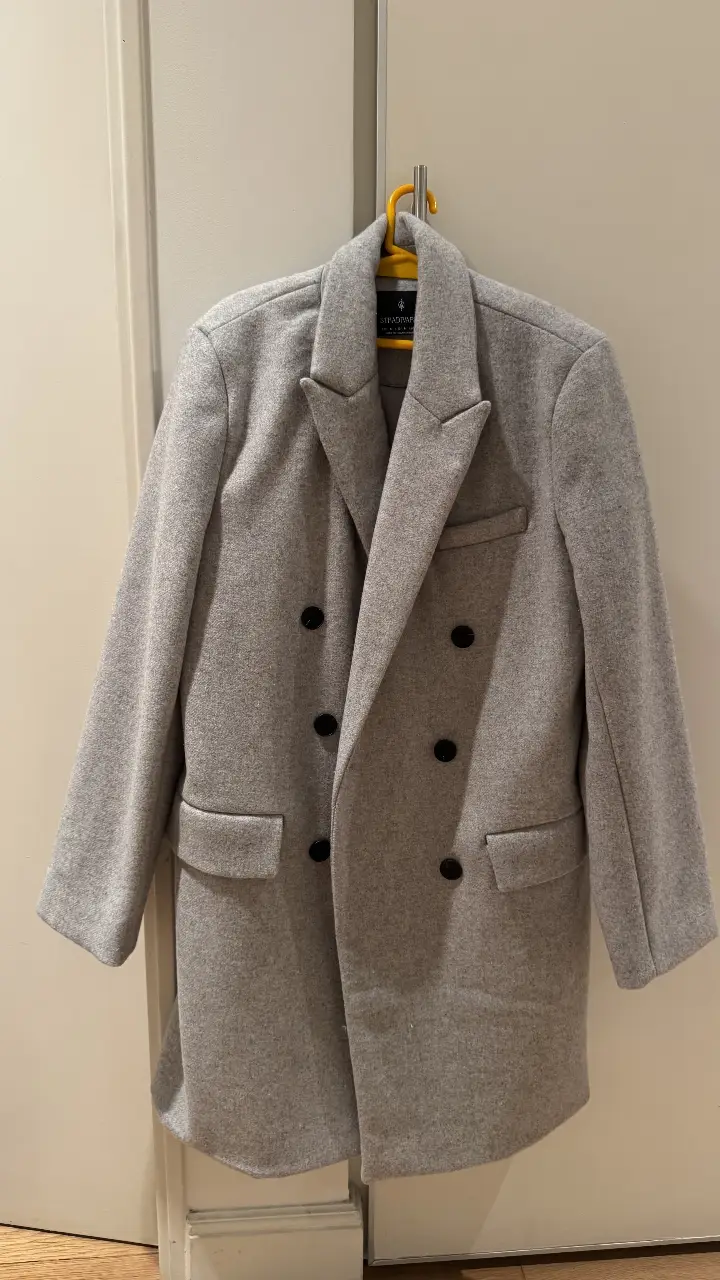 Sobretodo gris de paño, estilo clásico con doble botonadura y solapas. Ideal para un look elegante y abrigado en invierno. Marca Stradivarius, talle M.