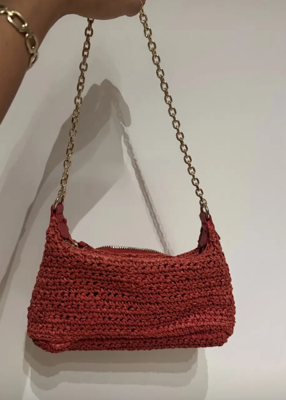Cartera de hombro tejida en color rojo, con cadena dorada. Ideal para un look casual y canchero.