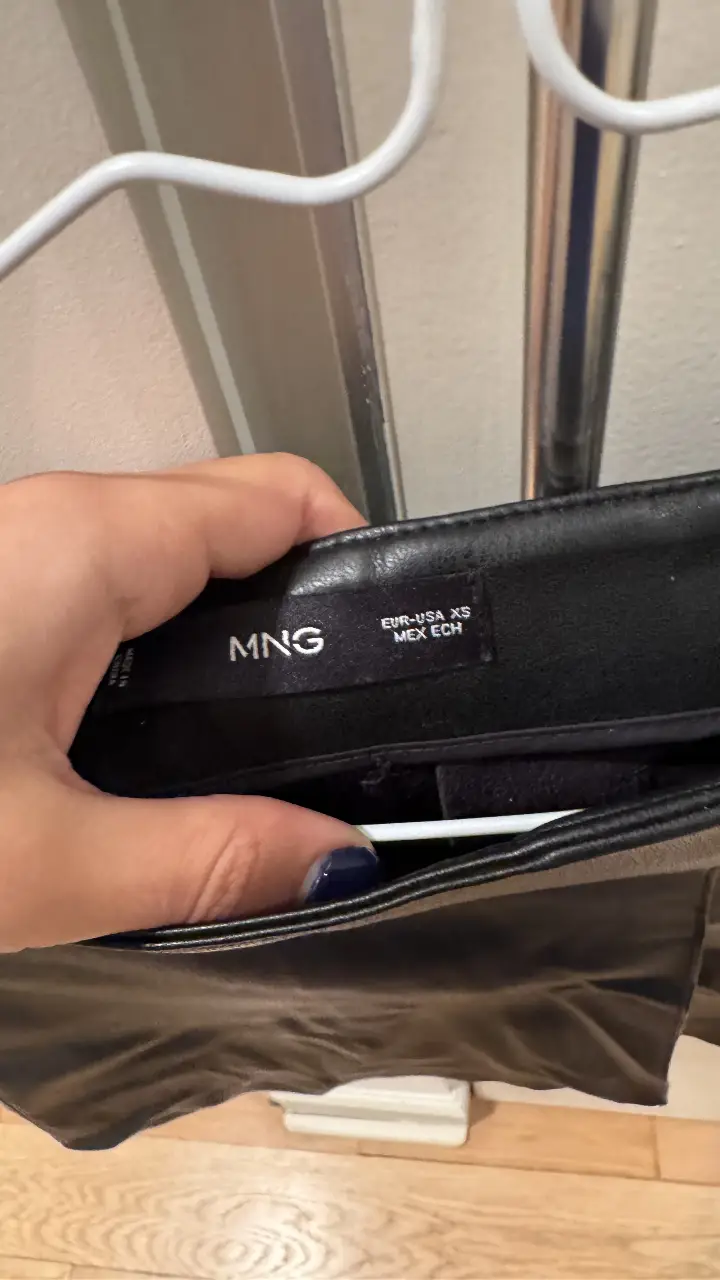 Pollera negra de cuero sintético de la marca MNG, talle XS. Ideal para un look elegante y moderno.