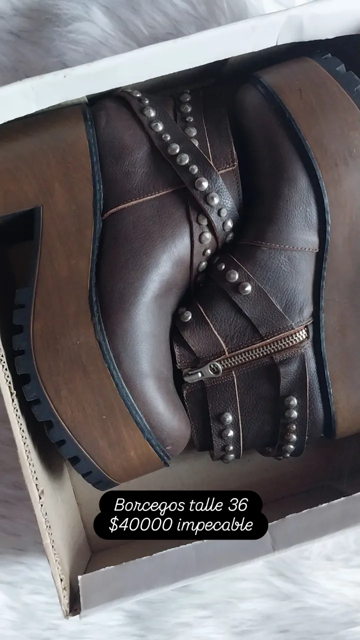 Borcegos de cuero marrón con tachas y hebillas. Plataforma de madera y suela track.