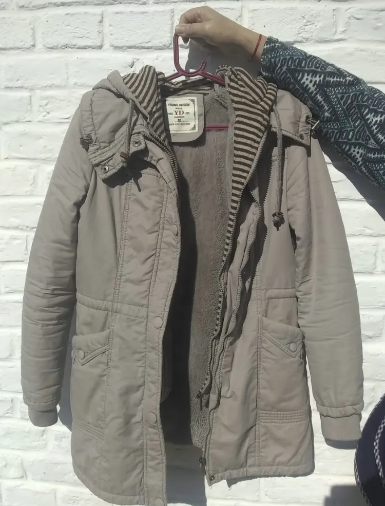 Campera de paño forrada con corderito, ideal para el frío. Tiene capucha con detalles a rayas y bolsillos frontales. Cierre completo y botones.