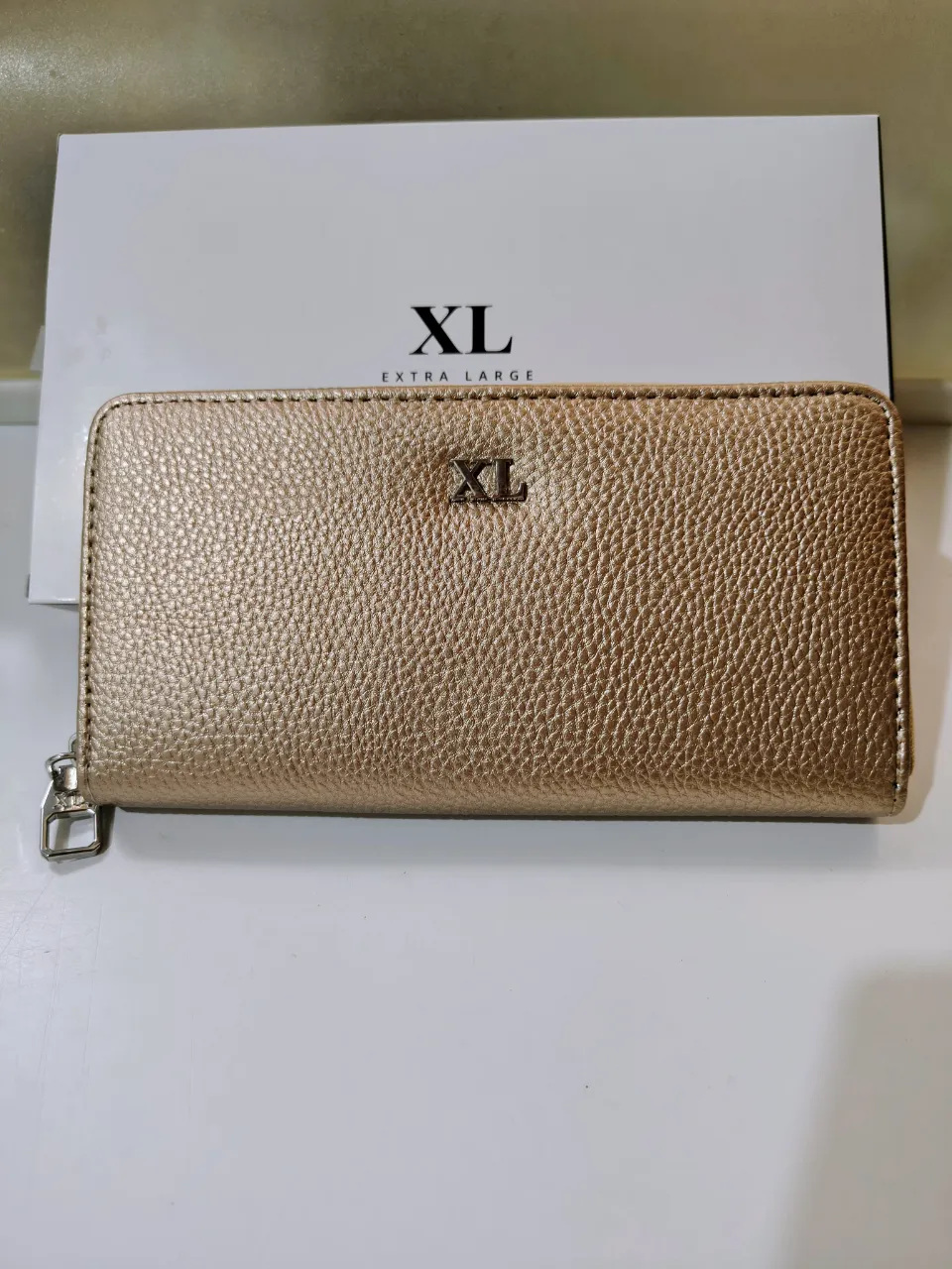 Billetera fichero XL de cuero sintético color dorado con cierre completo. Posee múltiples compartimentos internos para tarjetas y documentos. Sobria y elegante