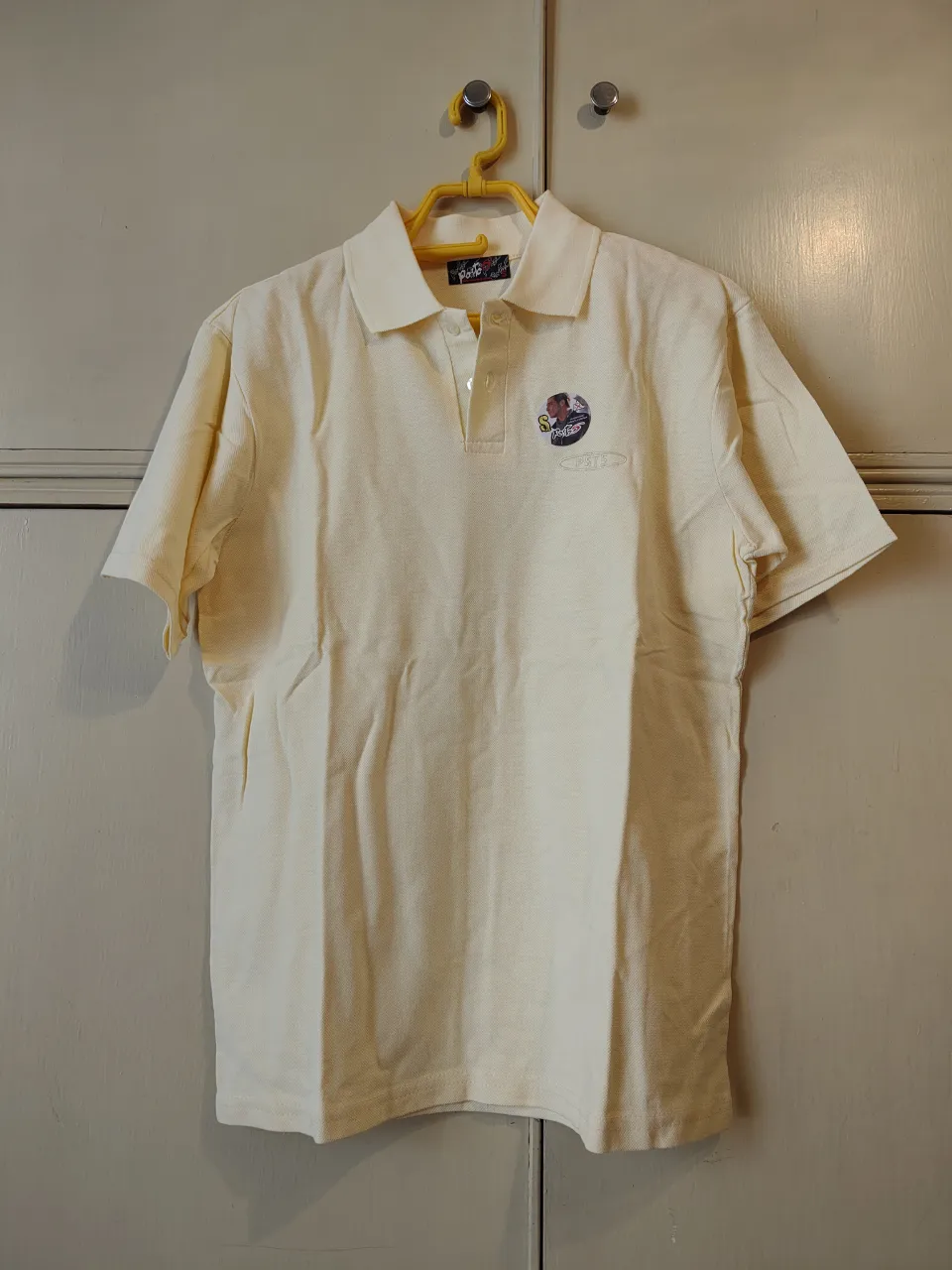 Remera polo color amarillo pálido con cuello y botones, en algodón Piqué. Ancho hombros 46 cm, largo 68 cm