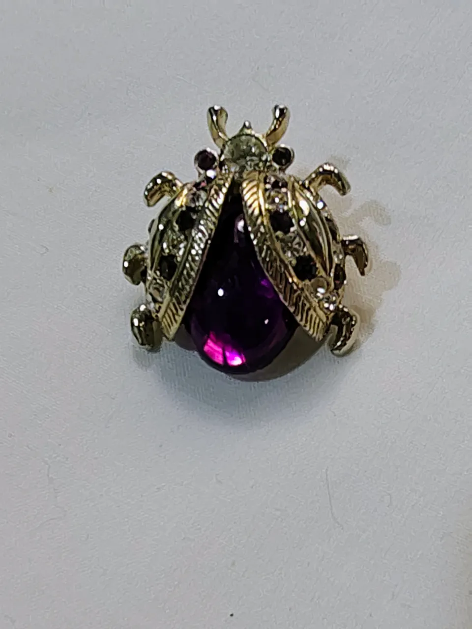 Broche vintage con forma de mariquita, con detalles de piedras y una piedra central morada. 3, 5 cm de alto x 2, 5 cm de ancho