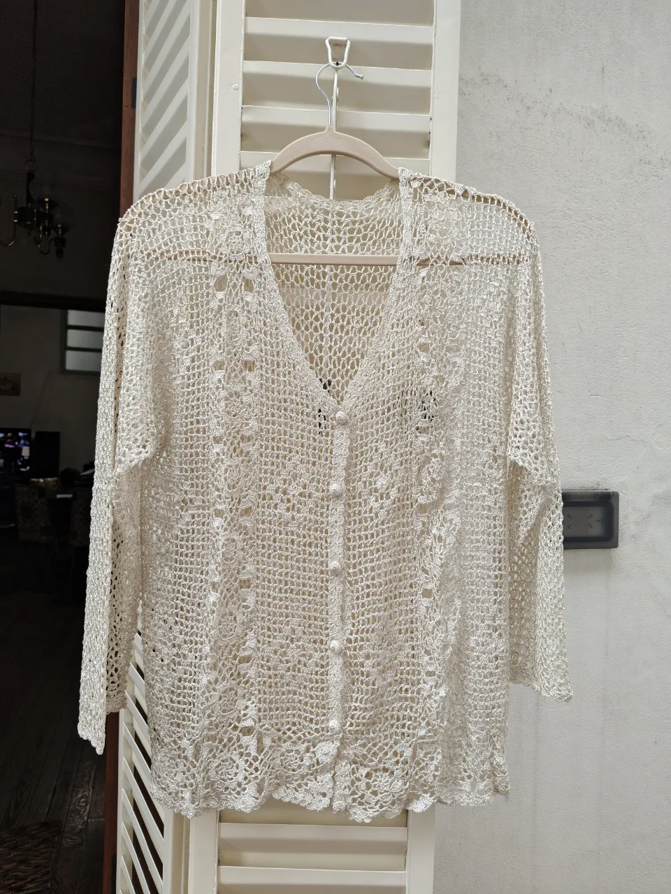 Cardigan tejido en  crochet simulando encaje, con vivos de raso al tono, en color crudo, botones nacarados y mangas largas. Ancho hombros 36 CM, largo talle 46 CM, largo manga 50 cm