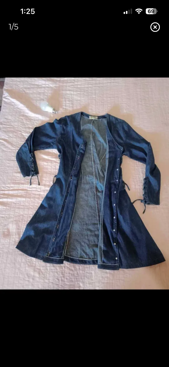 Vestido largo de jean, estilo camisero, con botones al frente y detalles de lazo en la espalda y mangas. Ideal para un look boho o casual.