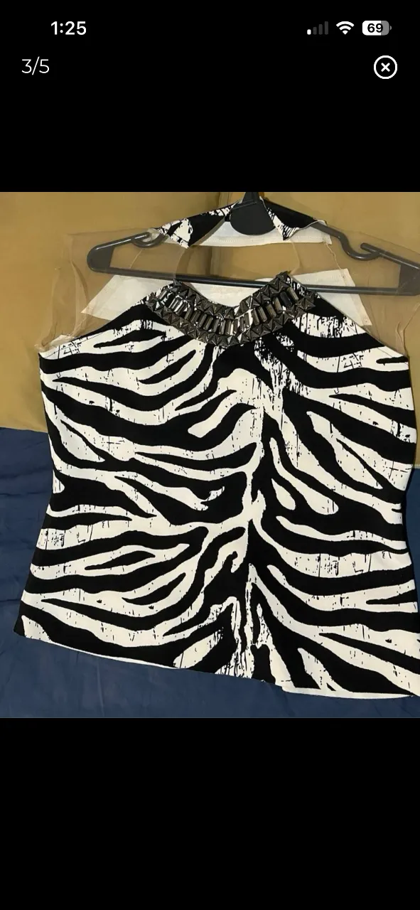 Top con estampa de cebra y detalles de pedrería en el cuello. Ideal para un look audaz y canchero.