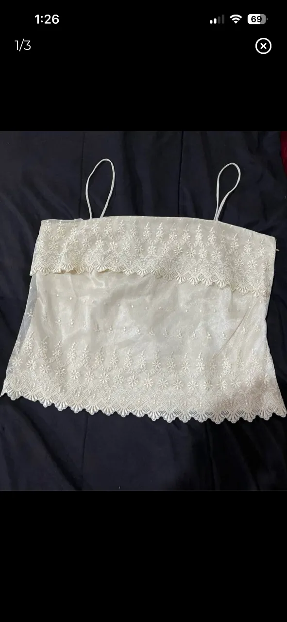 Top de fiesta color crudo con detalles de encaje y bordados florales. Posee tiras finas y cierre en la espalda. Ideal para eventos especiales o salidas elegantes.