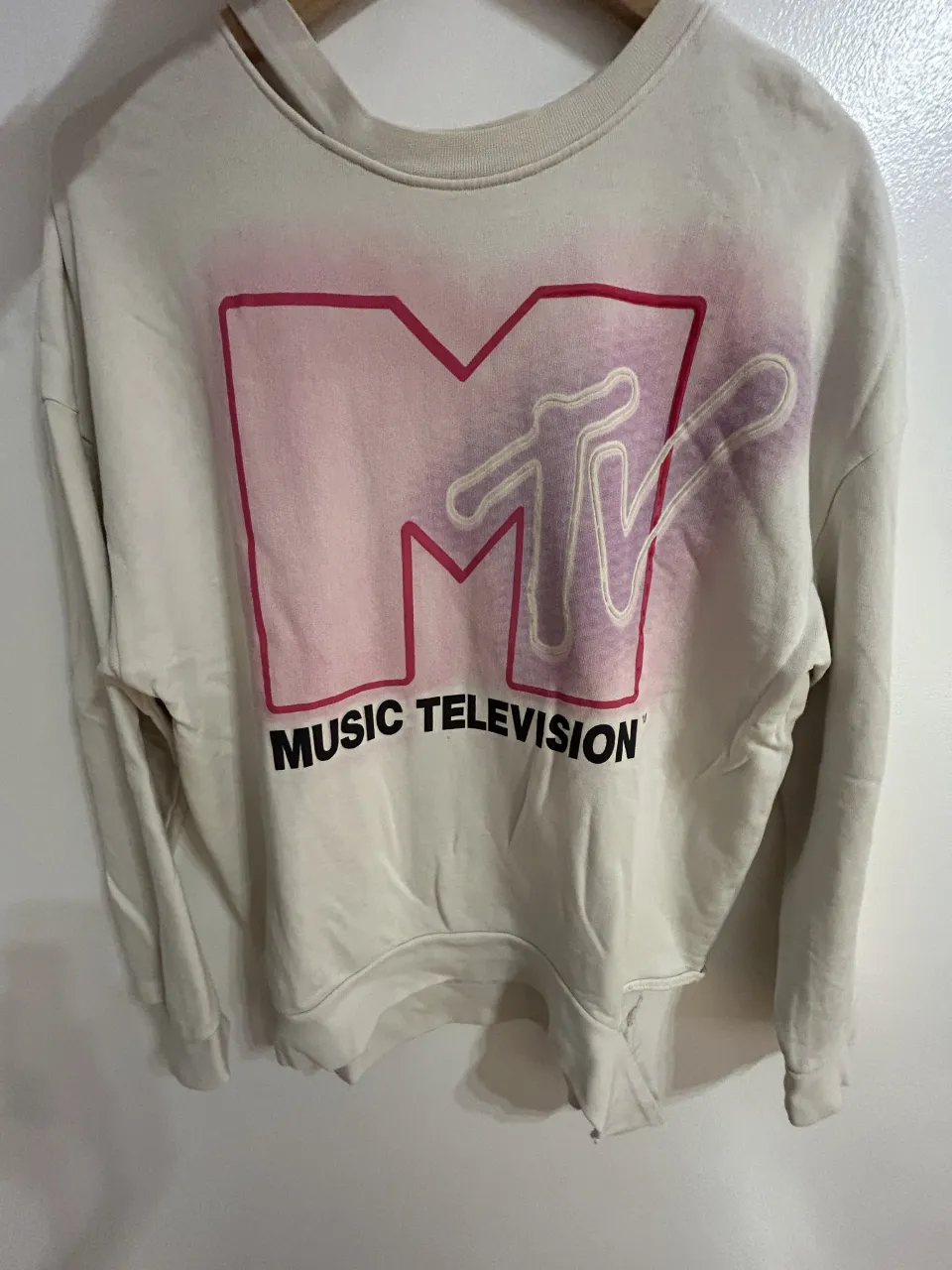 buzo de algodón color blanco con estampa del logo de MTV y la frase "MUSIC TELEVISION".