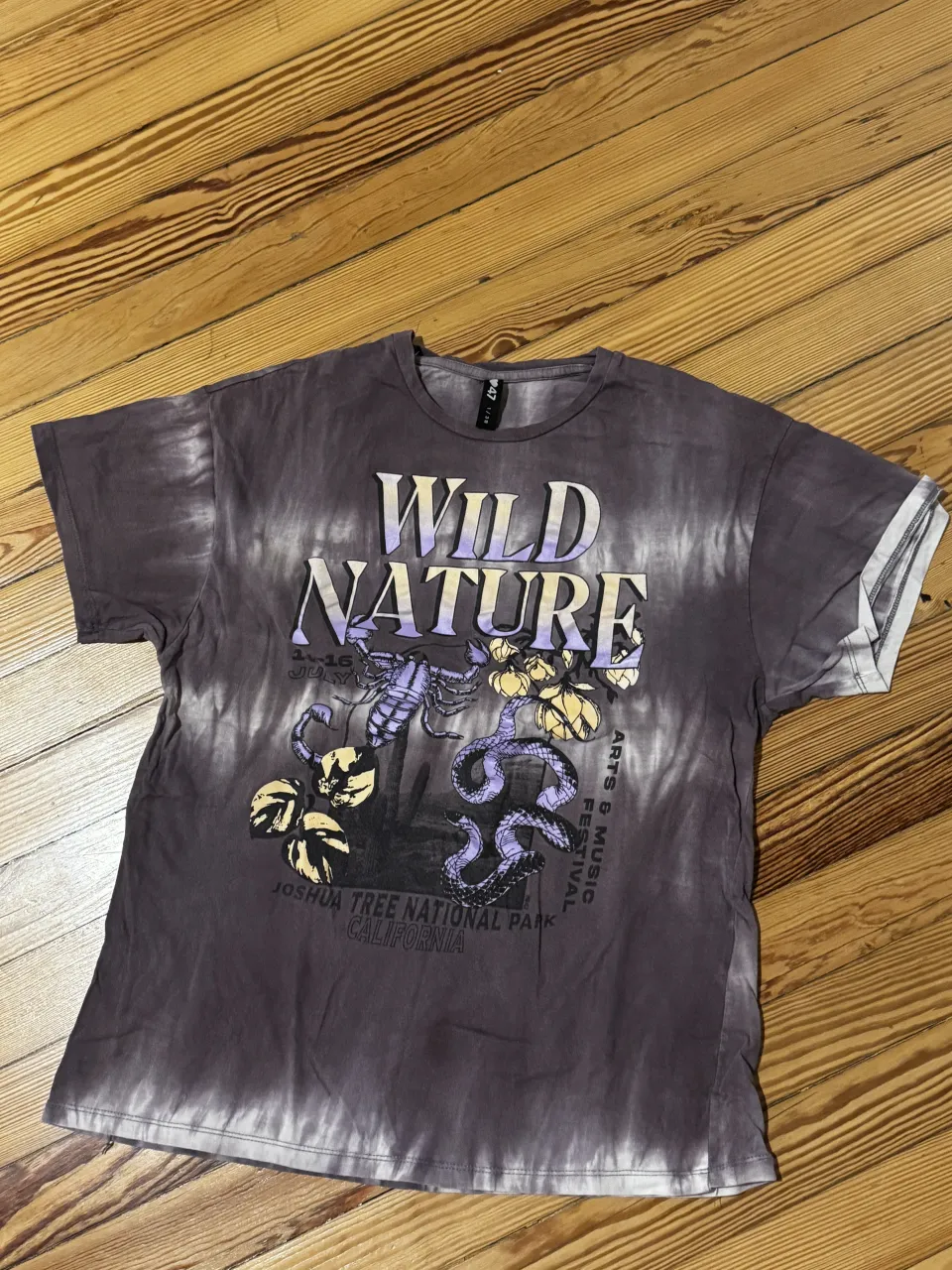 Remera estampada con diseño "Wild Nature" y tie-dye. Ideal para un look casual y relajado, perfecta para festivales o salidas al aire libre. Estilo único que evoca la naturaleza y la música.