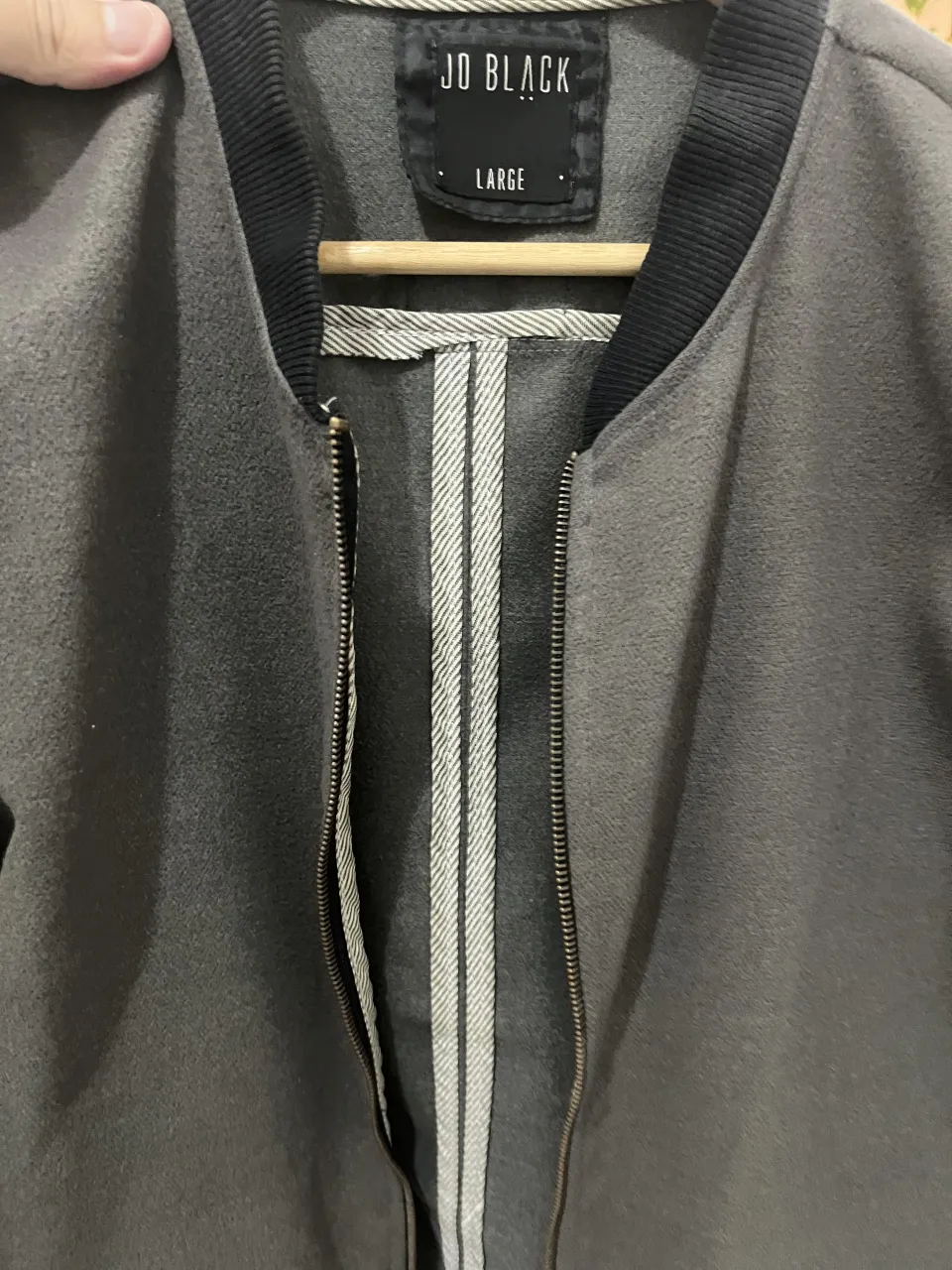 Campera bomber gris con mangas negras acolchadas. Cierre al frente y cuello redondo con detalles de ribb.