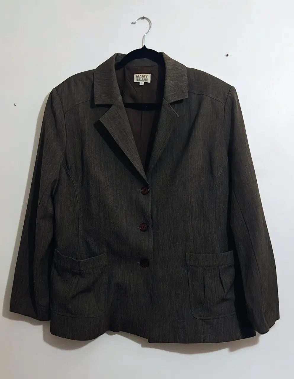Conjunto de blazer y pantalón sastrero marrón, ideal para un look formal o de trabajo. El blazer tiene un diseño clásico con botones y bolsillos, mientras que el pantalón es de corte recto. Perfecto para armar un outfit elegante y versátil.