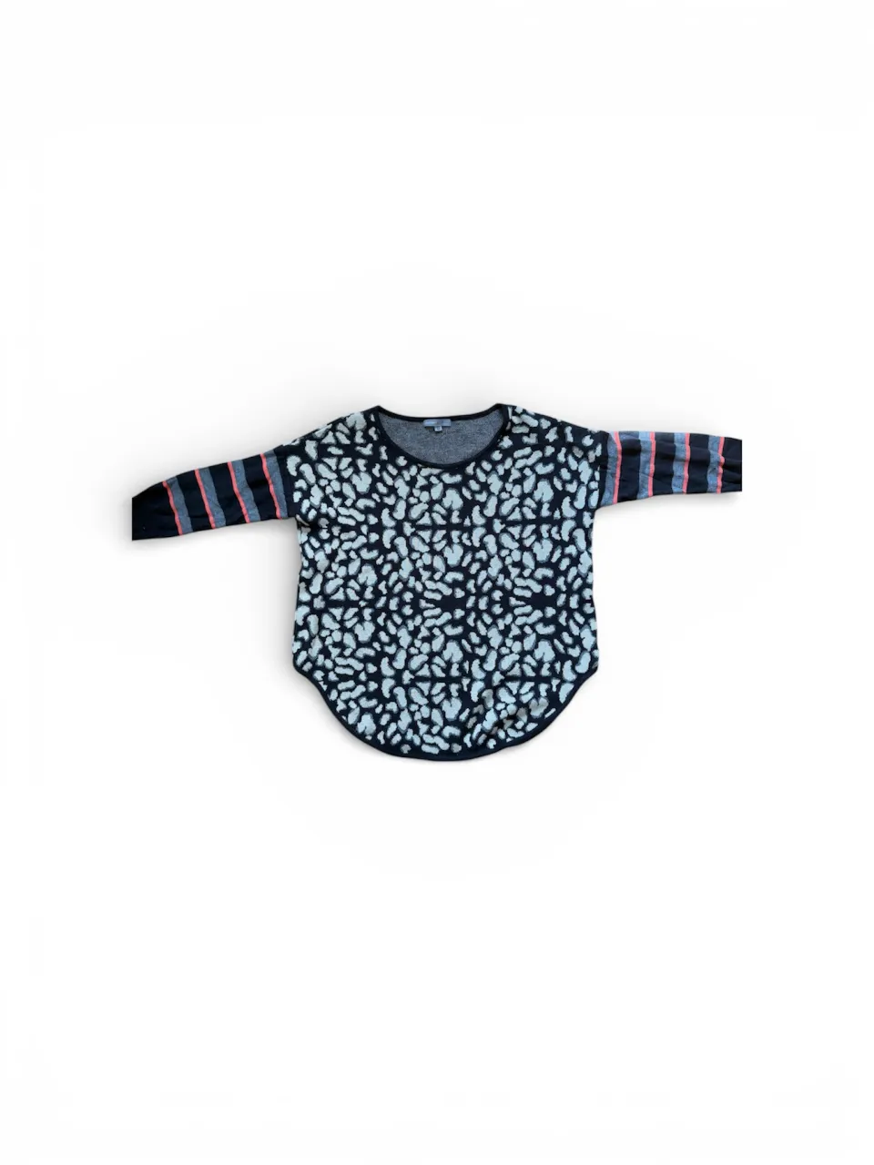 Sweater de manga larga con estampa abstracta en blanco y negro. Las mangas tienen un diseño de rayas horizontales en tonos de coral, gris y negro.