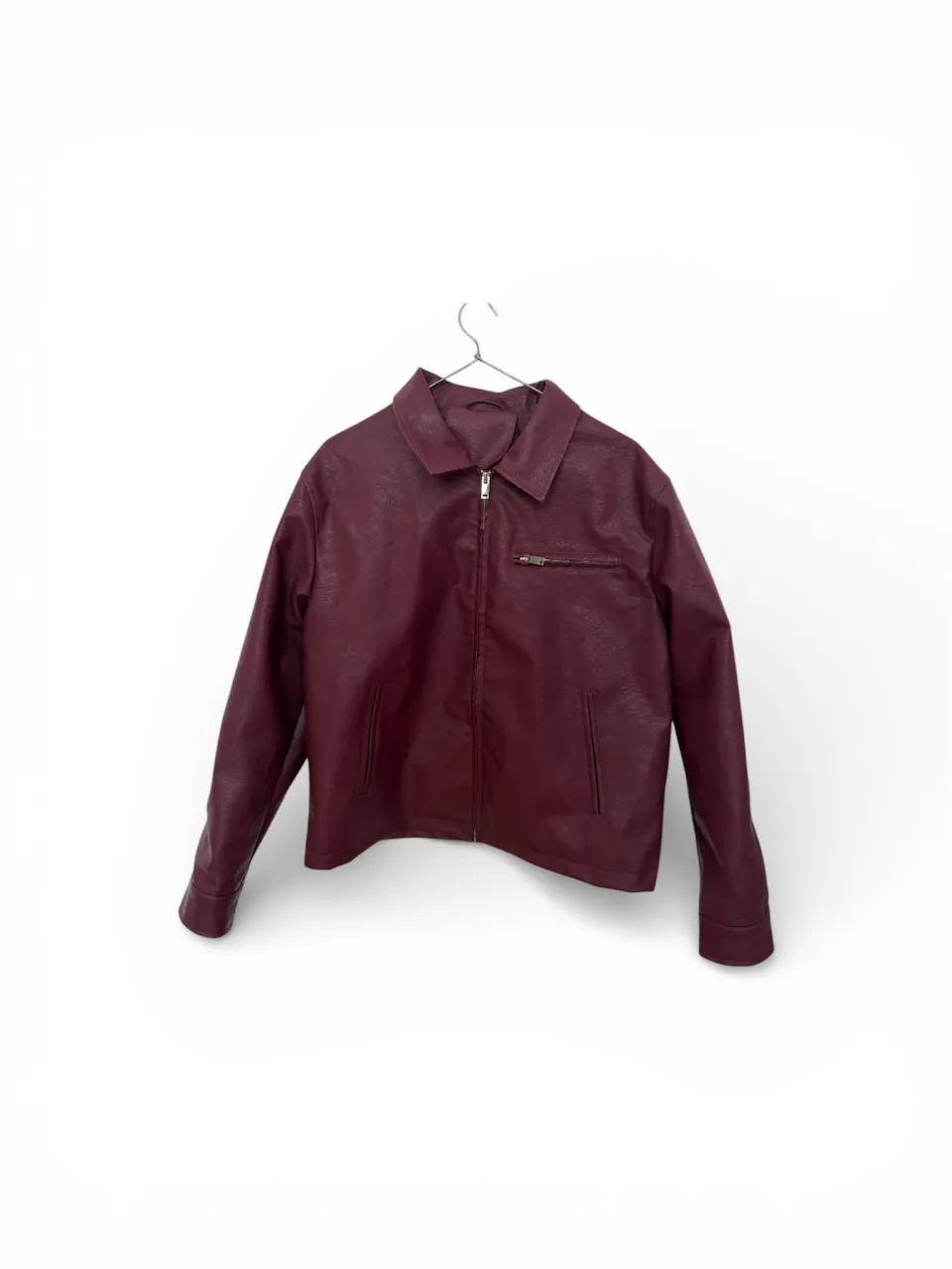 Campera de cuero sintético color bordó con cuello camisero y cierre al frente. Posee un bolsillo con cierre en el pecho del lado izquierdo.