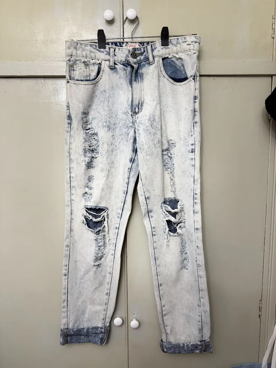 Jeans de mujer con efecto gastado y roturas. Tiro alto, corte recto y detalles deshilachados. Ideal para un look casual y moderno.