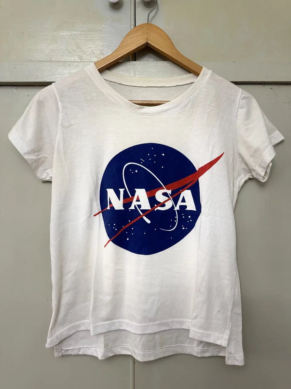 Remera blanca de manga corta con el logo de la NASA estampado en el pecho. Ideal para un look casual y urbano.