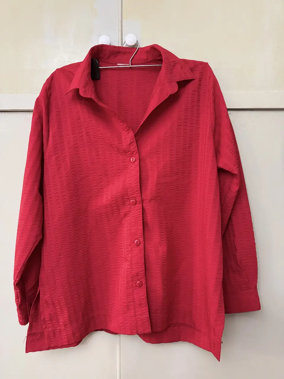Camisa roja de manga larga con textura, ideal para un look elegante y sofisticado. Perfecta para combinar con pantalones de vestir o jeans.