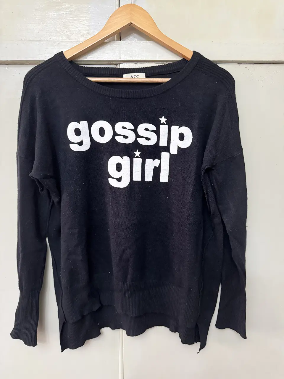 Sweater negro de algodón con estampado "gossip girl" en blanco. Ideal para un look casual y cómodo.
