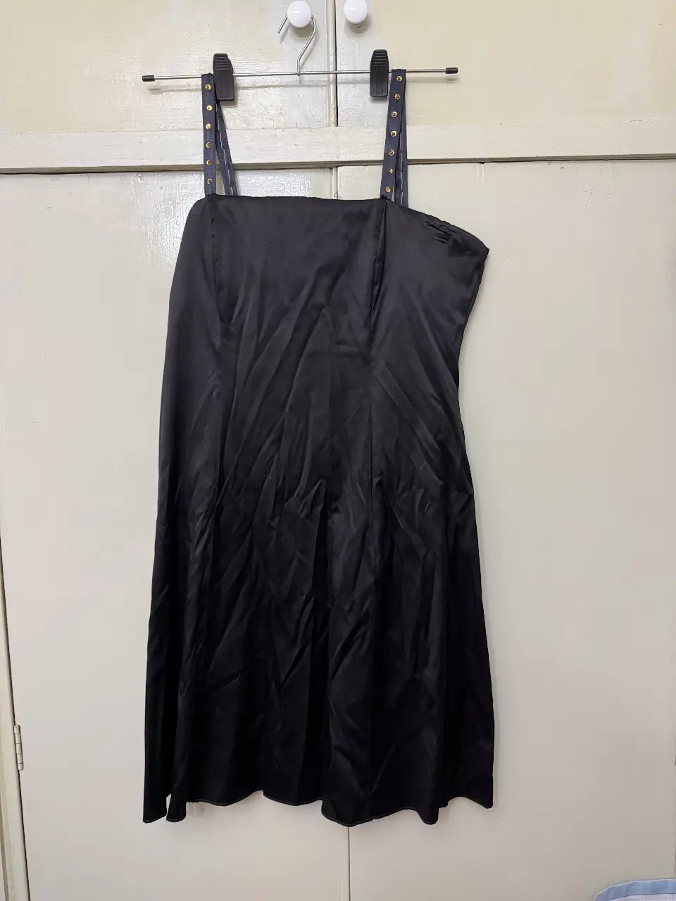 Vestido mini negro con tirantes finos y detalles dorados. Ideal para una fiesta o salida nocturna.
