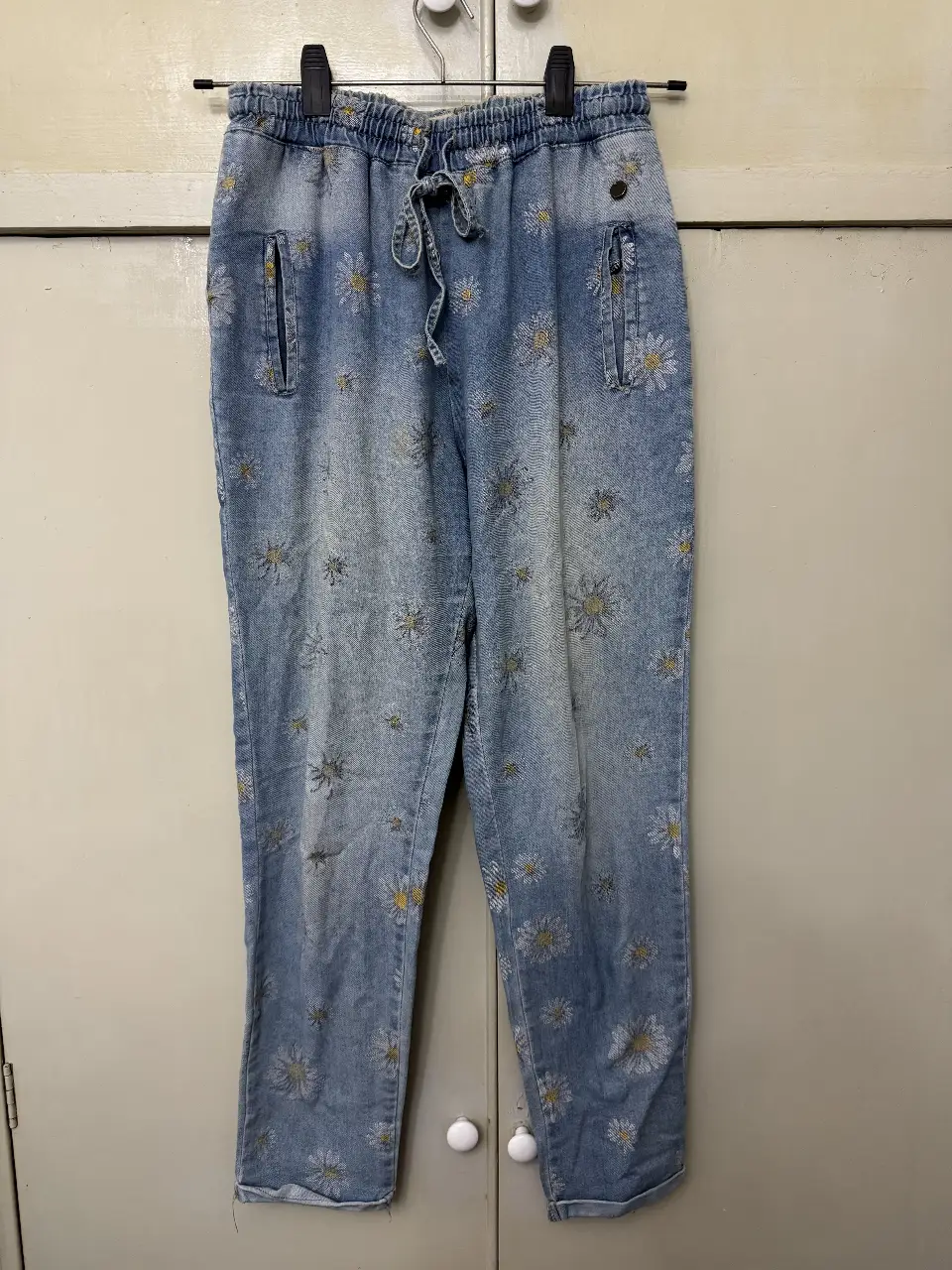 Pantalón de jean suelto con estampado de flores. Con cintura elastizada y cordón. Ideal para un look casual y cómodo.