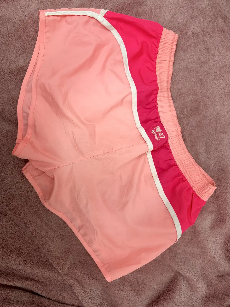 Short deportivo de mujer, color rosa con detalles en blanco y fucsia. Ideal para actividades físicas.