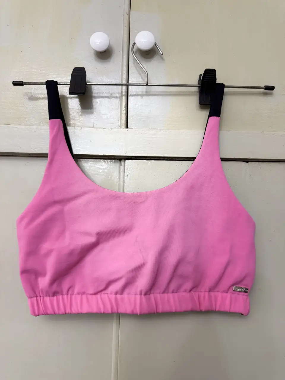 Top deportivo rosa con detalles en negro. Ideal para entrenamientoo. Diseño moderno y cómodo.