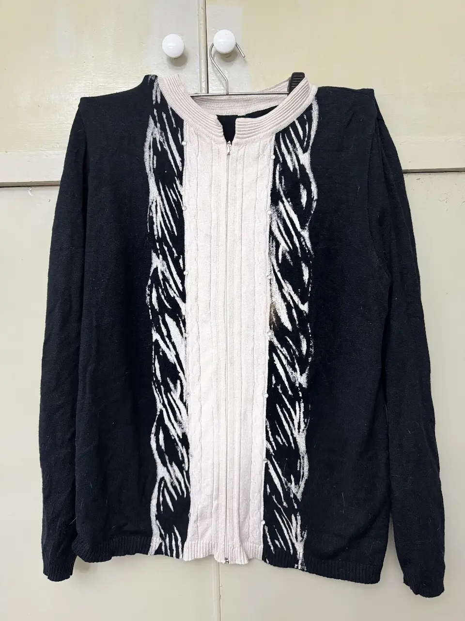 Cardigan de mujer con cierre, diseño con detalles en blanco y negro. Ideal para un look casual y moderno.