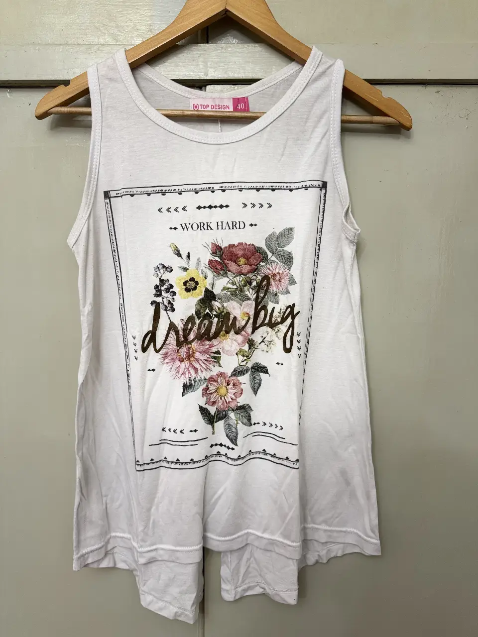 Musculosa blanca con estampado floral y frase "dream big". Ideal para un look casual y fresco.